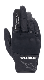 Alpinestars Honda Copper Glove, czarne miejskie rękawice motocyklowe, teksturowana konstrukcja mesh, biały napis „Honda Motor Co. Ltd. Est. 1948” na palcu wskazującym, logo „HONDA” i obrys gwiazdy Alpinestars na nadgarstku, twarda ochrona kostek, lekki sprzęt do jazdy szosowej