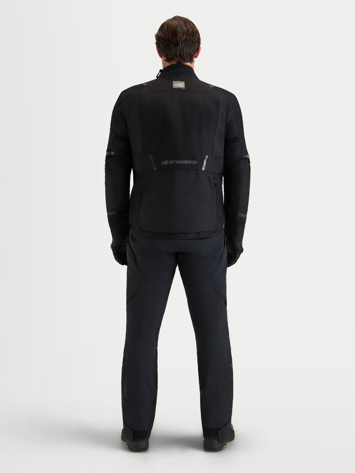 Alpinestars St-7 V2 2L Gore-Tex kurtka motocyklowa męska adventure, czarna, widok z tyłu na model prezentujący techniczną wodoodporną konstrukcję tekstylną i branding Alpinestars
