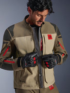 Kurtka Alpinestars Nazca 3L GORE-TEX PRO, Walnut Rock Brown, motocyklowa kurtka adventure z rozpiętym przodem odsłaniającym centralny siatkowy panel wentylacyjny, czerwone logo All Terra, noszona z czarnymi rękawicami motocyklowymi GORE-TEX, odzież techniczna do turystyki off-road