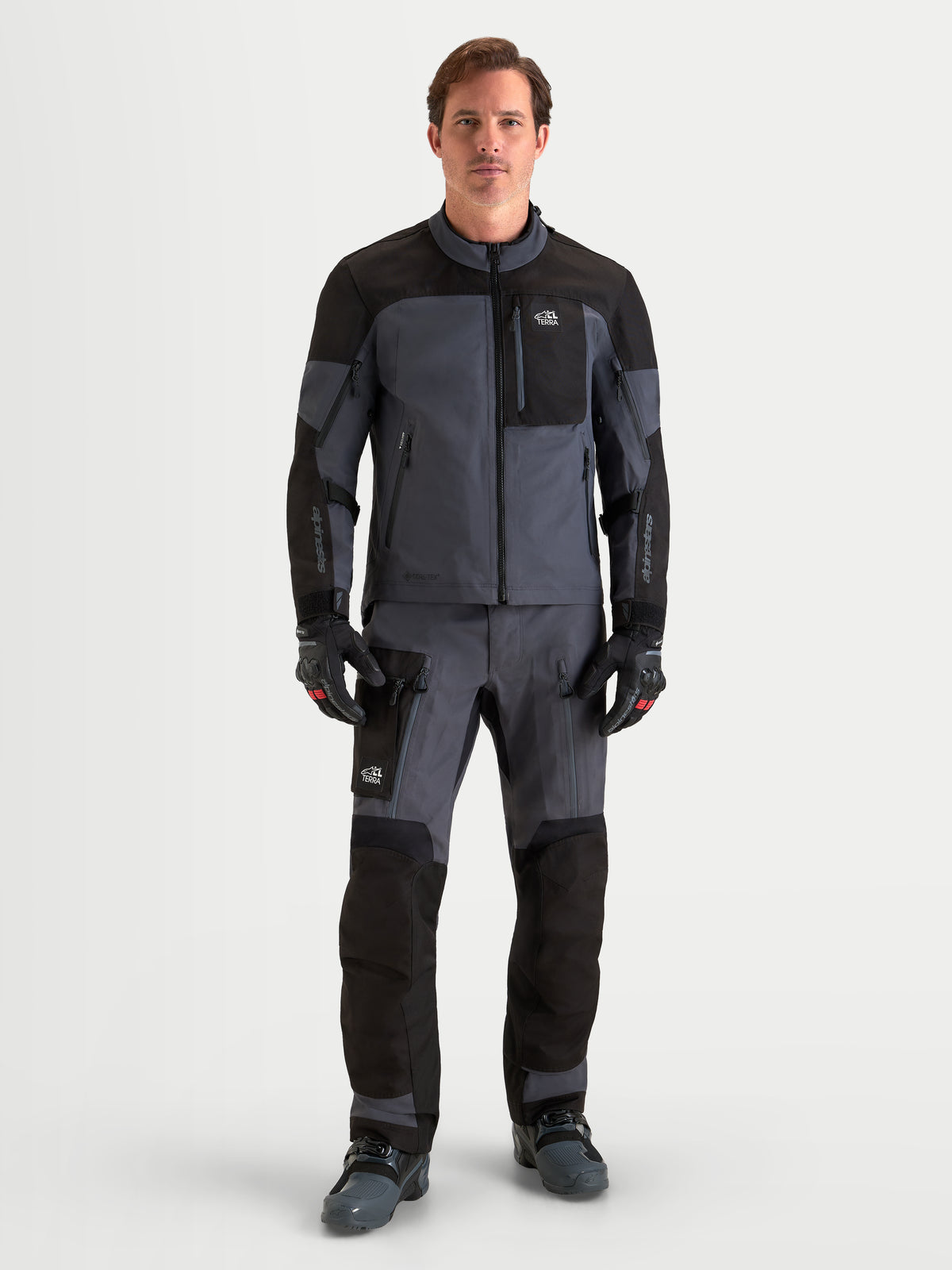 Alpinestars Arenis Gore-Tex Gear Set, męski zestaw motocyklowy adventure, czarny i ciemnoszary, widok z przodu na model w wodoodpornej odzieży turystycznej