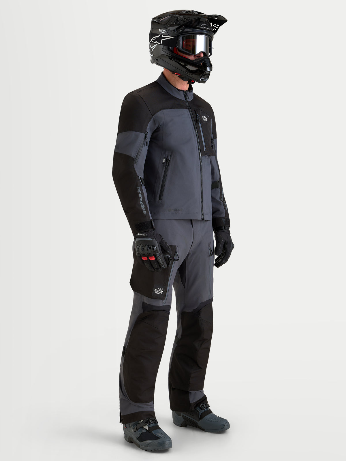 Alpinestars Arenis Gore-Tex Jacket, men's all-terrain adventure motorcycle jacket in black and deep gray, side profile view showing waterproof textile construction, ergonomic collar, and protective gear setup