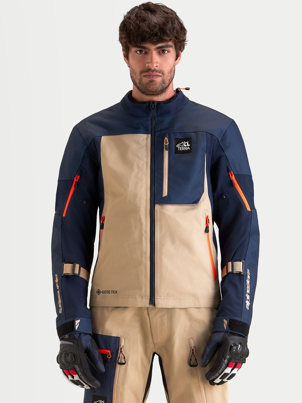Alpinestars Arenis Gore-Tex kurtka motocyklowa męska adventure, ciemnoniebieska i beżowa, widok z przodu na model w pasującym sprzęcie i rękawicach, wodoodporna konstrukcja tekstylna
