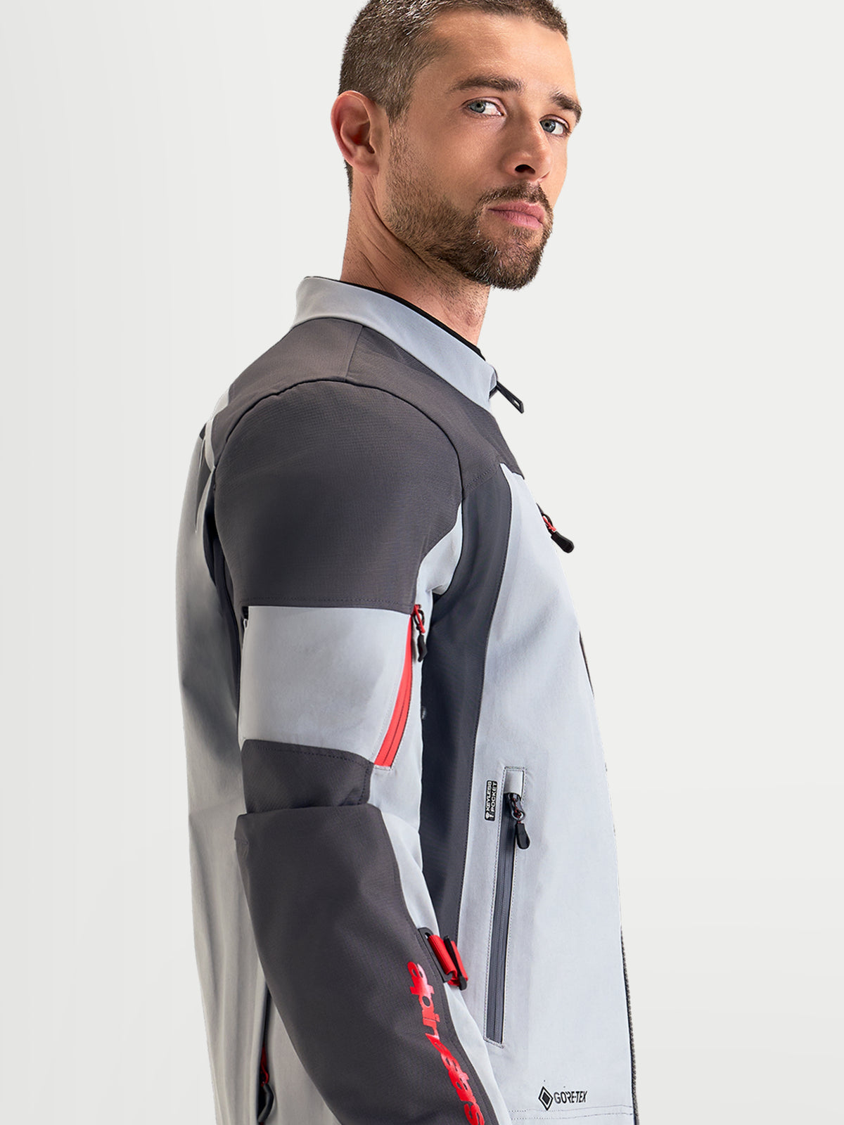 Alpinestars Arenis Gore-Tex kurtka motocyklowa męska adventure, w kolorze jasnoszarym, ciemnoszarym i czarnym, widok z boku na wodoodporną konstrukcję tekstylną i ergonomiczny kołnierz