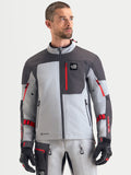 Alpinestars Arenis Gore-Tex kurtka motocyklowa adventure męska w kolorze jasnoszarym, ciemnoszarym i czarnym, widok z przodu na modelu prezentującym wodoodporną konstrukcję tekstylną i zapinaną na zamek kieszeń na piersi