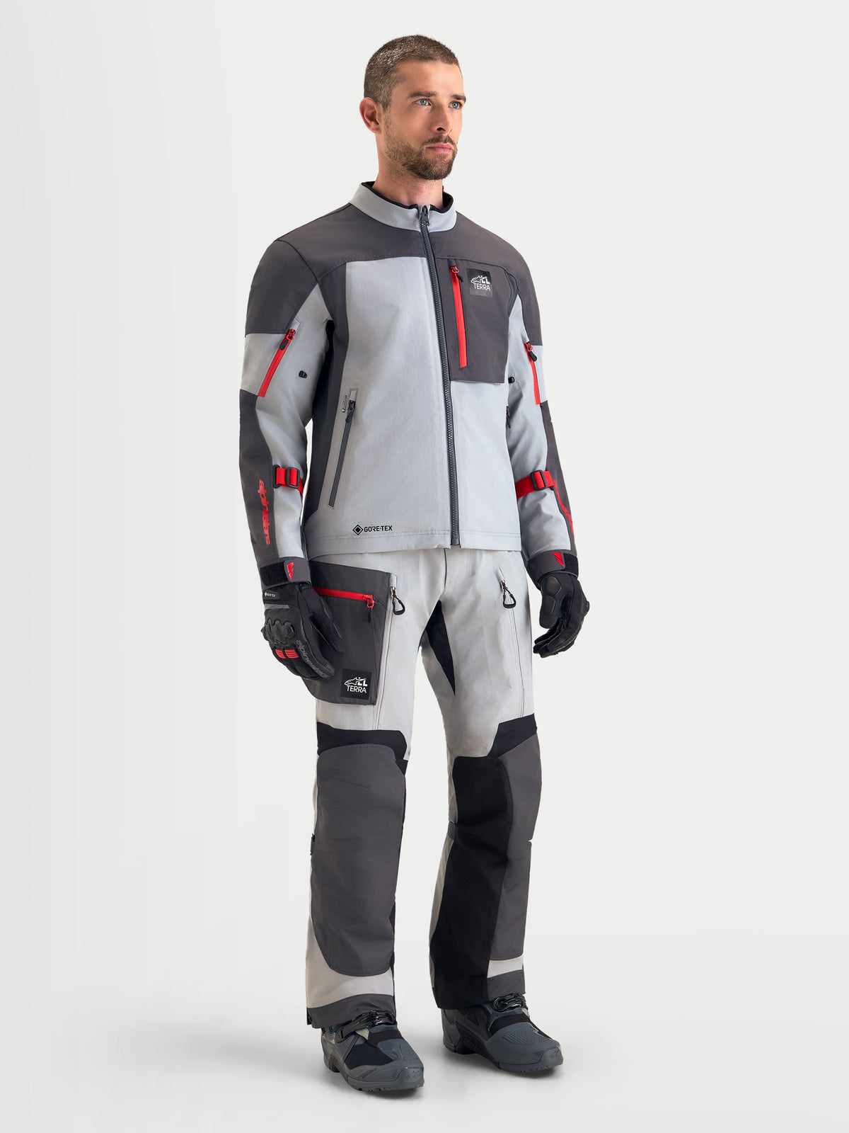 Alpinestars Arenis Gore-Tex kurtka motocyklowa męska adventure, szara, ciemnoszara i czarna, na modelu prezentującym wodoodporną konstrukcję tekstyliów i pasujący sprzęt do jazdy