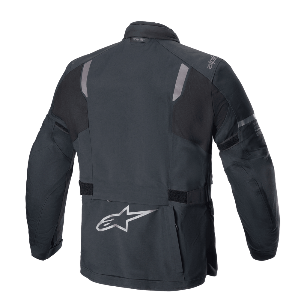 Kurtka Alpinestars ST-7 2L GORE-TEX, widok z tyłu, czarno-ciemnoszara, z odblaskowymi panelami na barkach, srebrnym logo gwiazdy Alpinestars na dole pleców i regulowanymi paskami w talii, odzież motocyklowa adventure touring