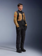 Kurtka Alpinestars ST-7 2L GORE-TEX, kurtka motocyklowa, kolor Gobi Brown i czarny, prezentowana przez modela z pasującymi czarnymi spodniami i rękawicami, brązowe panele na klatce piersiowej i rękawach, czarne akcenty techniczne i pomarańczowe logo, odzież motocyklowa adventure-touring.