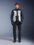 Kurtka Alpinestars ST-7 2L GORE-TEX, turystyczna kurtka motocyklowa adventure, kolor Ice Gray, granatowy i czarny, noszona z czarnymi spodniami i rękawicami, duże przednie kieszenie cargo, czerwone akcenty na rękawach, laminowana powłoka GORE-TEX zapewniająca wodoodporność.