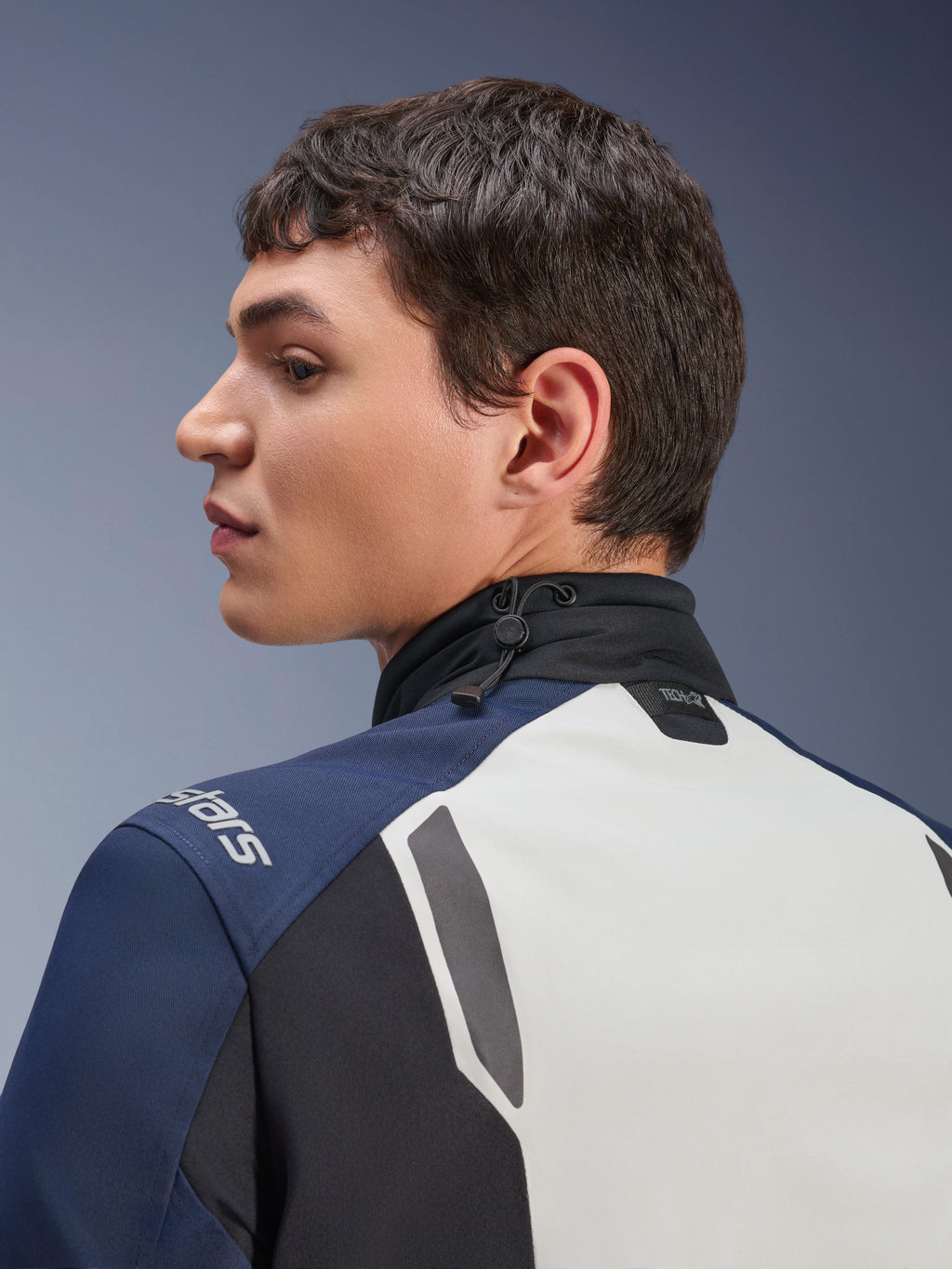 Kurtka Alpinestars ST-7 2L GORE-TEX, zbliżenie z profilu na plecy i kołnierz, kolor Ice Gray Dark Blue i czarny, regulowany kołnierz ze ściągaczem, logo Tech-Air, motocyklowa kurtka turystyczna adventure premium