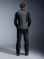 Kurtka Alpinestars ST-7 2L GORE-TEX, Deep Gray Black i Dark Khaki, widok z tyłu na modelu, motocyklowa kurtka turystyczna typu adventure z szarym panelem tylnym i czarnymi profilowanymi rękawami, noszona z pasującymi czarnymi spodniami.