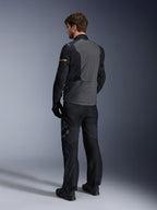 Kurtka Alpinestars ST-7 2L GORE-TEX, ciemnoszara i czarna z akcentami dark khaki, widok od tyłu motocyklisty w kurtce i pasujących spodniach motocyklowych, odzież adventure touring, wodoodporna laminowana konstrukcja