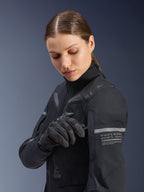 Damska kurtka Alpinestars Stella ST-7 2L GORE-TEX, motocyklowa kurtka turystyczna typu adventure, czarna i ciemnoszara, noszona przez kobietę regulującą detal na rękawie, odblaskowe paski z grafiką współrzędnych, wytrzymała tekstylna powłoka do jazdy całorocznej