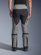 Spodnie Alpinestars Nazca 3L GORE-TEX PRO, motocyklowe spodnie adventure, ciemnoszare i czarne, widok z tyłu, wyposażone w zapinane na zamek wyloty wentylacyjne na udach, regulatory objętości łydek i wzmocnione panele na siedzeniu, zaprojektowane do ekstremalnej jazdy w terenie.