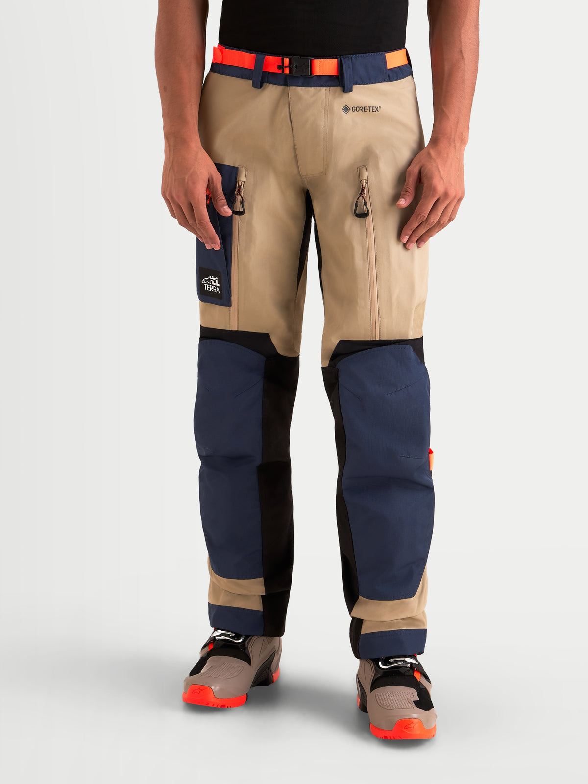 Alpinestars Arenis Gore-Tex spodnie motocyklowe adventure męskie w kolorze granatowym i beżowym, widok z przodu na model w wodoodpornej odzieży z wentylacją ud i wzmocnioną ochroną kolan