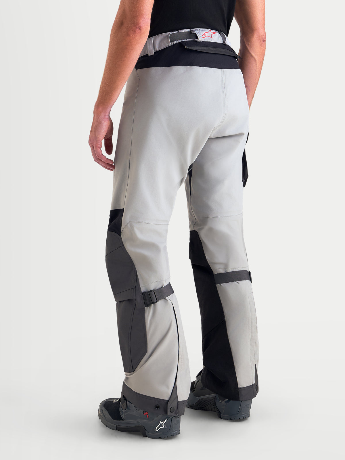 Alpinestars Arenis Gore-Tex spodnie motocyklowe adventure męskie w kolorze średnioszarym, ciemnoszarym i czarnym, widok z tyłu na modelu prezentujący wodoodporną konstrukcję tekstylną oraz wzmocnione strefy kolan i siedziska