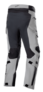 Alpinestars Boulder 3L GORE-TEX Pants, motocyklowe spodnie adventure, ciemnoszare i czarne, widok z tyłu pod kątem trzech czwartych pokazujący wzmocnione siedzenie i wewnętrzne części nogawek, jasnoszare panele, logo GORE-TEX na łydce oraz ergonomiczne kieszenie cargo.