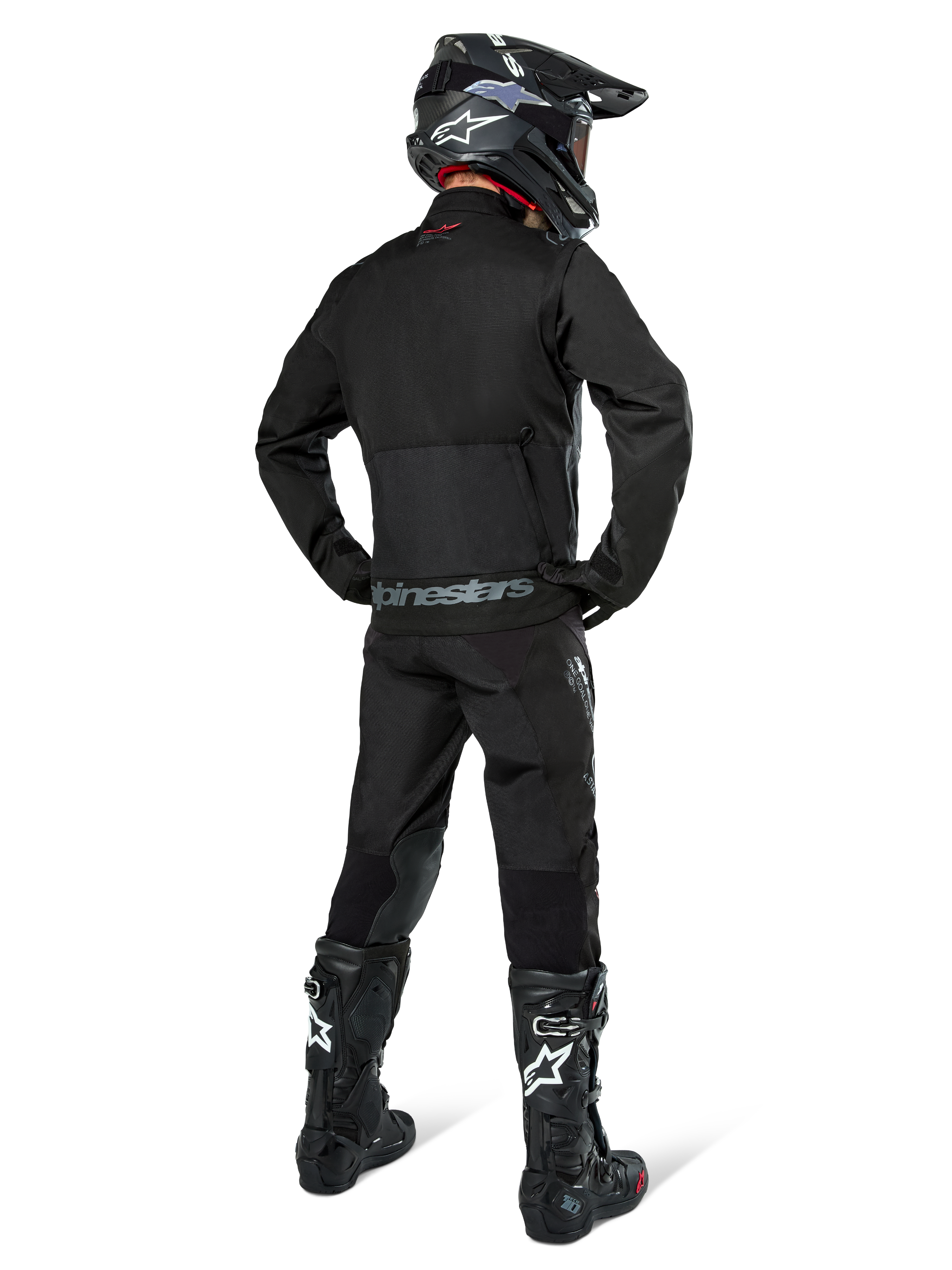 Alpinestars Pro-Dura Jacket, czarna kurtka off-road enduro, widok z tyłu w zestawie z pasującymi spodniami i czarnymi butami Tech 10, wyraźne logo Alpinestars na dole pleców, wytrzymała konstrukcja tekstylna do agresywnej jazdy po szlakach