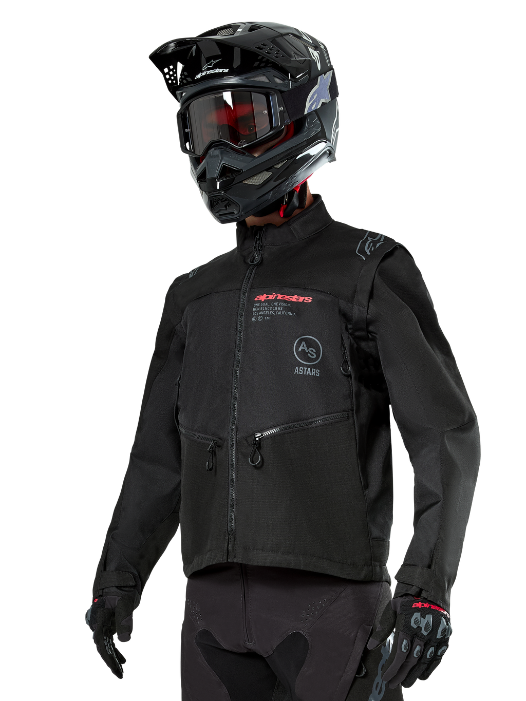 Alpinestars Pro-Dura Jacket, motocyklowa kurtka off-road, czarna z czerwonymi i szarymi elementami graficznymi, posiada przednie kieszenie na zamek i wysoki kołnierz, zestawiona z czarnym kaskiem motocrossowym i rękawicami do jazdy enduro