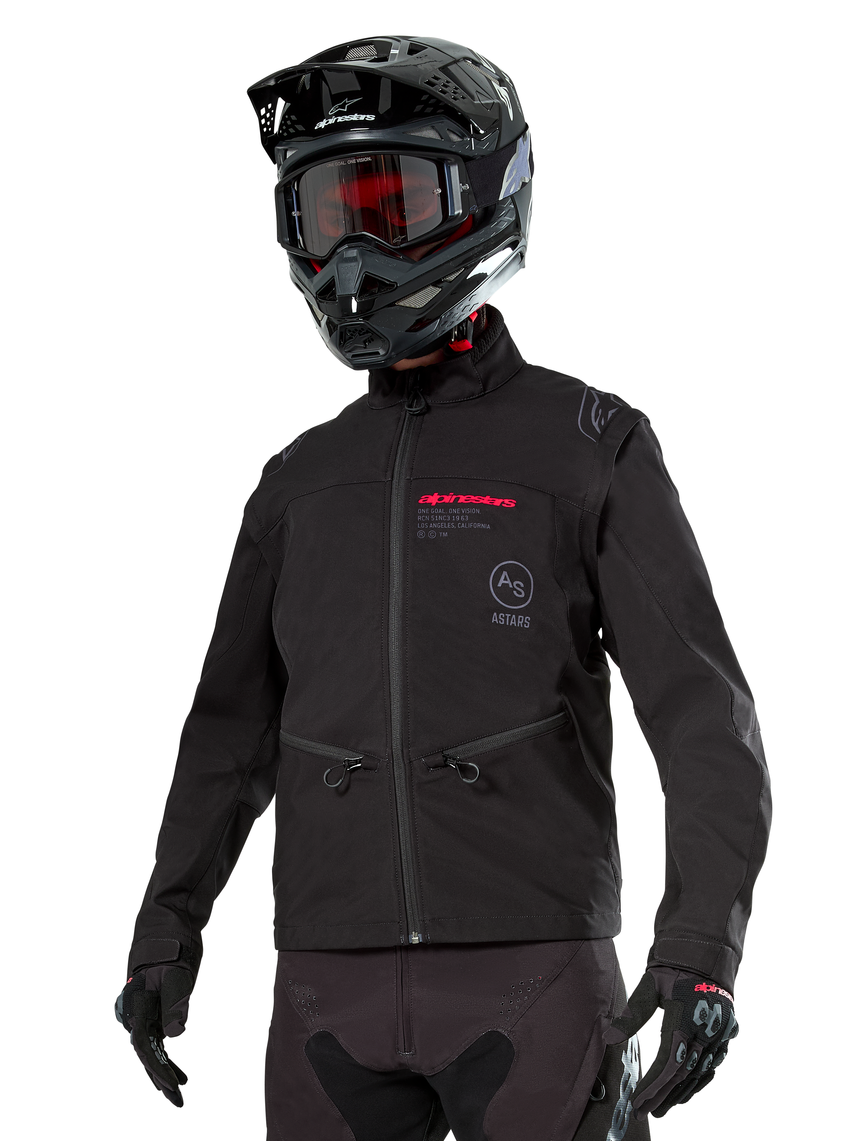 Kurtka Alpinestars Lite-Dura Softshell, czarna terenowa kurtka motocyklowa z czerwonym brandingiem i logo AS, noszona z czarnym kaskiem motocrossowym, czerwonymi goglami i czarnymi rękawicami, kieszenie na ręce zapinane na zamek, regulowane mankiety, przeznaczona do jazdy enduro