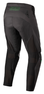 Alpinestars Techstar Phantom Pants, spodnie motocrossowe, antracytowe i neonowo-zielone, widok z tyłu z neonowo-zielonym brandingiem „ASTARS” w pasie, siatkowymi panelami wentylacyjnymi z tyłu nogawek i wzmocnionym siedziskiem zapewniającym trwałość w wyścigach terenowych