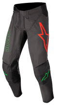 Alpinestars Techstar Phantom Pants, spodnie motocrossowe, antracytowe i neonowo-zielone, z dużym logo czerwonej gwiazdy na lewym udzie, zielonym napisem ASTARS z boku, wzmocnionymi czarnymi panelami na kolanach, regulowanym zapięciem zapadkowym w pasie, wytrzymała odzież wyczynowa do wyścigów motocrossowych