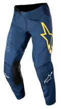 Alpinestars Techstar Phantom Pants, spodnie motocrossowe, ciemnoniebieskie z żółtymi i białymi akcentami, czarne skórzane panele na kolanach, duże żółte logo gwiazdy na udzie, białe oznaczenia ASTARS, wytrzymała tkanina stretch rip-stop do wyścigów off-road