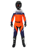 Motocross rider wearing Alpinestars Pro-Dura Pants in Navy Hot Orange White, featuring a matching long-sleeve jersey, black helmet with goggles, black gloves, and black motocross boots, complete off-road racing gear.