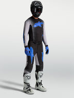 Alpinestars Supertech Hiten AFD Pants, black and blue motocross gear set on model with matching jersey and white boots.