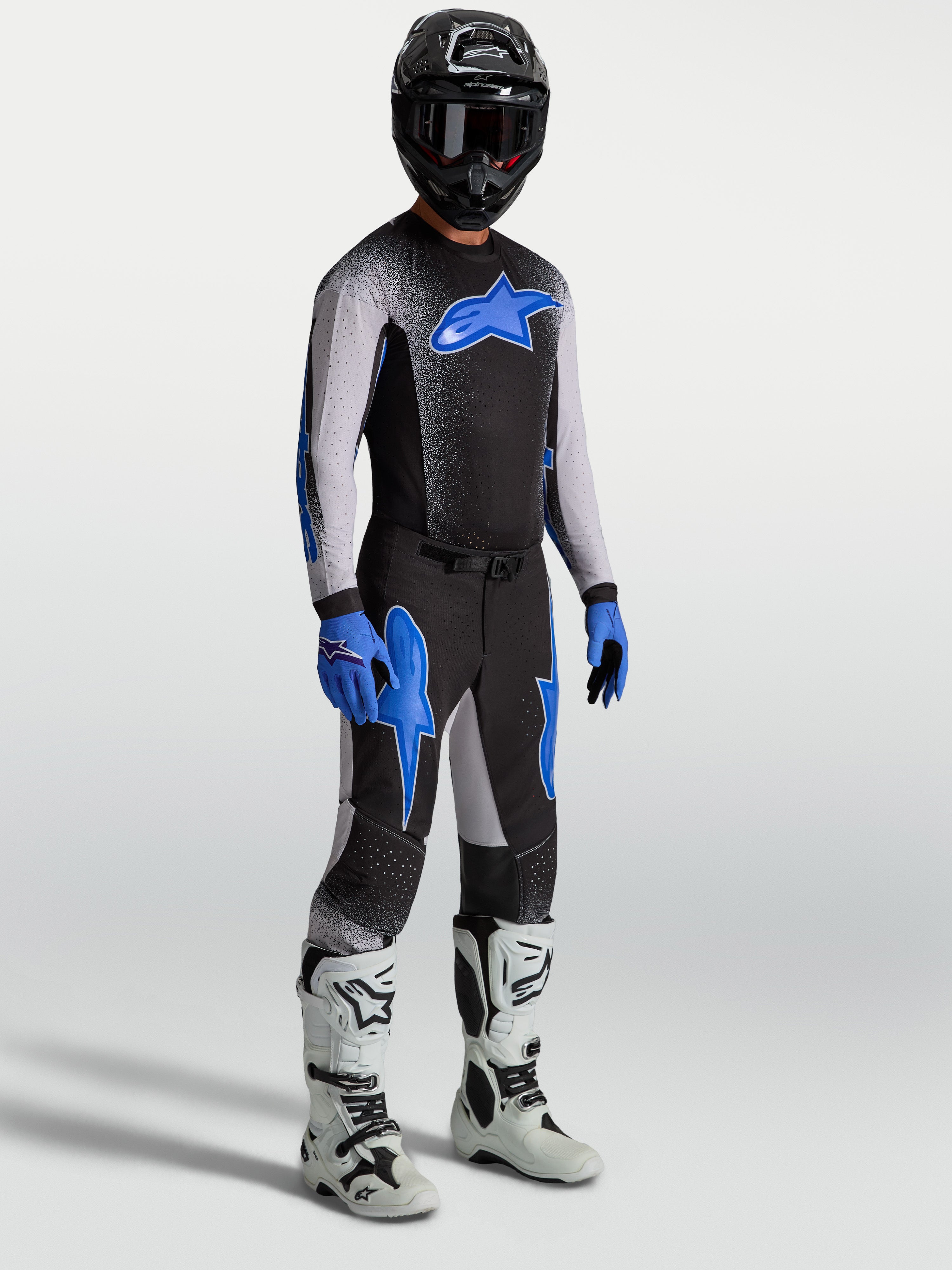Alpinestars Supertech Hiten AFD Pants, black and blue motocross gear set on model with matching jersey and white boots.