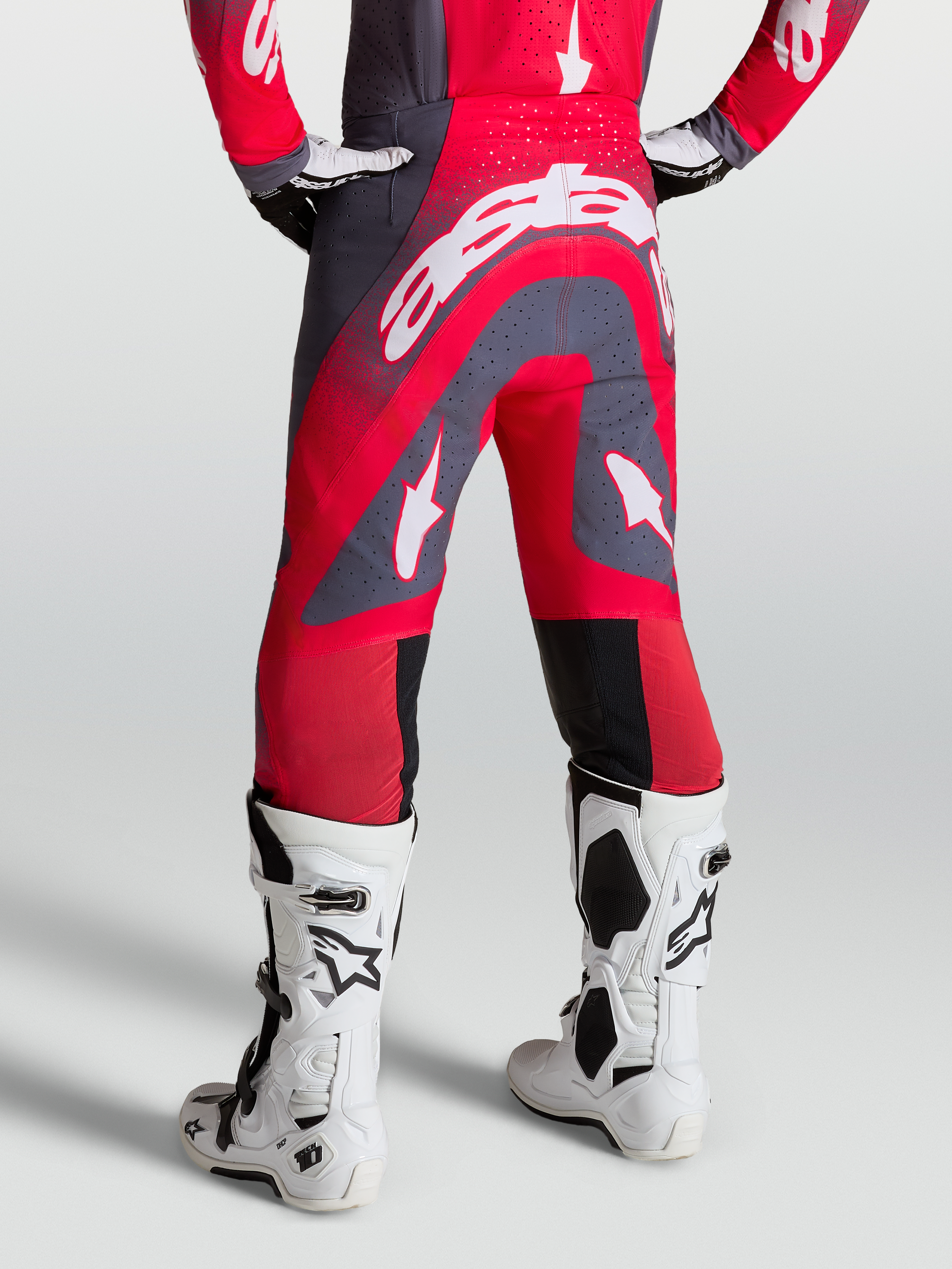 Alpinestars Supertech Hiten AFD Pants, red and graystone motocross pants, on-model rear view with white racing boots.