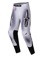 Alpinestars Supertech Maker Pants 2025, spodnie motocrossowe, srebrno-czarne, duże czarne logo Astars na udach, czerwony branding techniczny na biodrze, czarne skórzane panele wewnętrzne na kolanach, perforowane strefy wentylacyjne