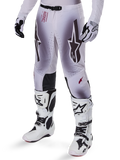 Alpinestars Supertech Maker Pants 2025, spodnie motocrossowe, srebrno-czarne, z dużym logo gwiazdy i czerwonymi napisami, prezentowane z dopasowanymi białymi butami i rękawicami