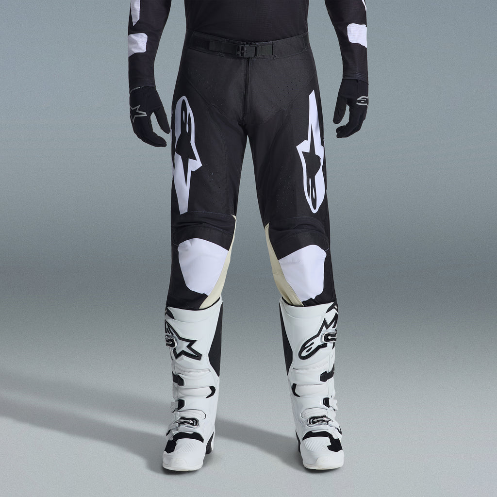 Zestaw Alpinestars 2026 Racer Air Riway, czarno-białe spodnie motocrossowe z beżowymi panelami wewnętrznymi na kolanach, w połączeniu z białymi butami wyścigowymi i czarnymi rękawicami, lekki wentylowany strój wyścigowy off-road
