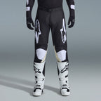 Zestaw Alpinestars 2026 Racer Air Riway, czarno-białe spodnie motocrossowe z beżowymi panelami wewnętrznymi na kolanach, w połączeniu z białymi butami wyścigowymi i czarnymi rękawicami, lekki wentylowany strój wyścigowy off-road