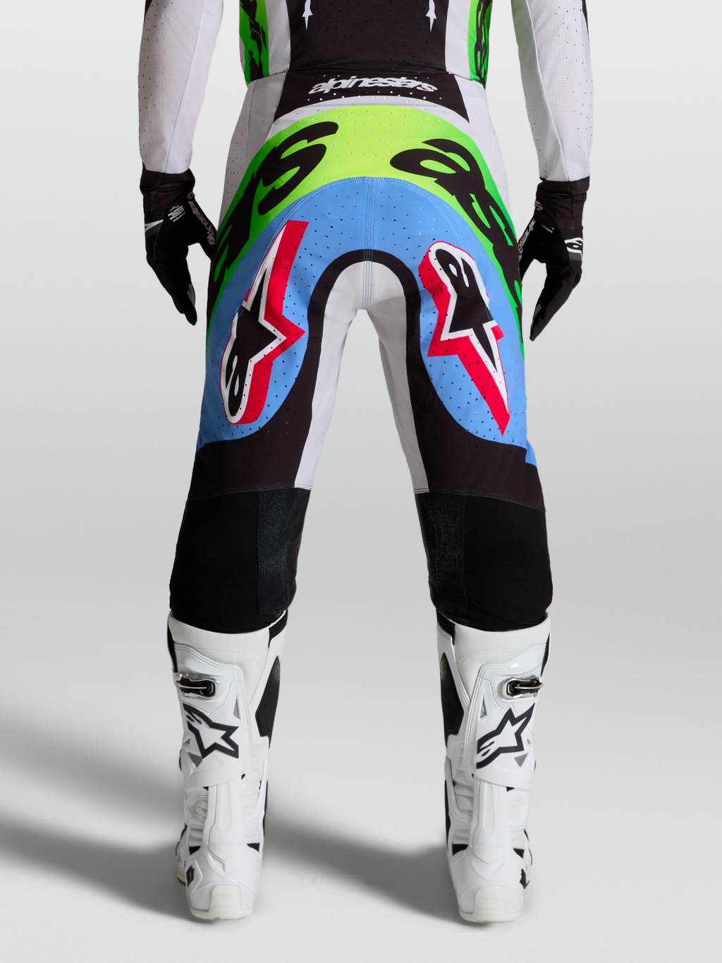 Alpinestars Supertech Dyna, męskie spodnie motocrossowe, jasny liliowy i neonowy zielony, widok z tyłu, perforowane panele.