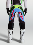 Alpinestars Supertech Dyna, męskie spodnie motocrossowe, jasny liliowy i neonowy zielony, widok z tyłu, perforowane panele.