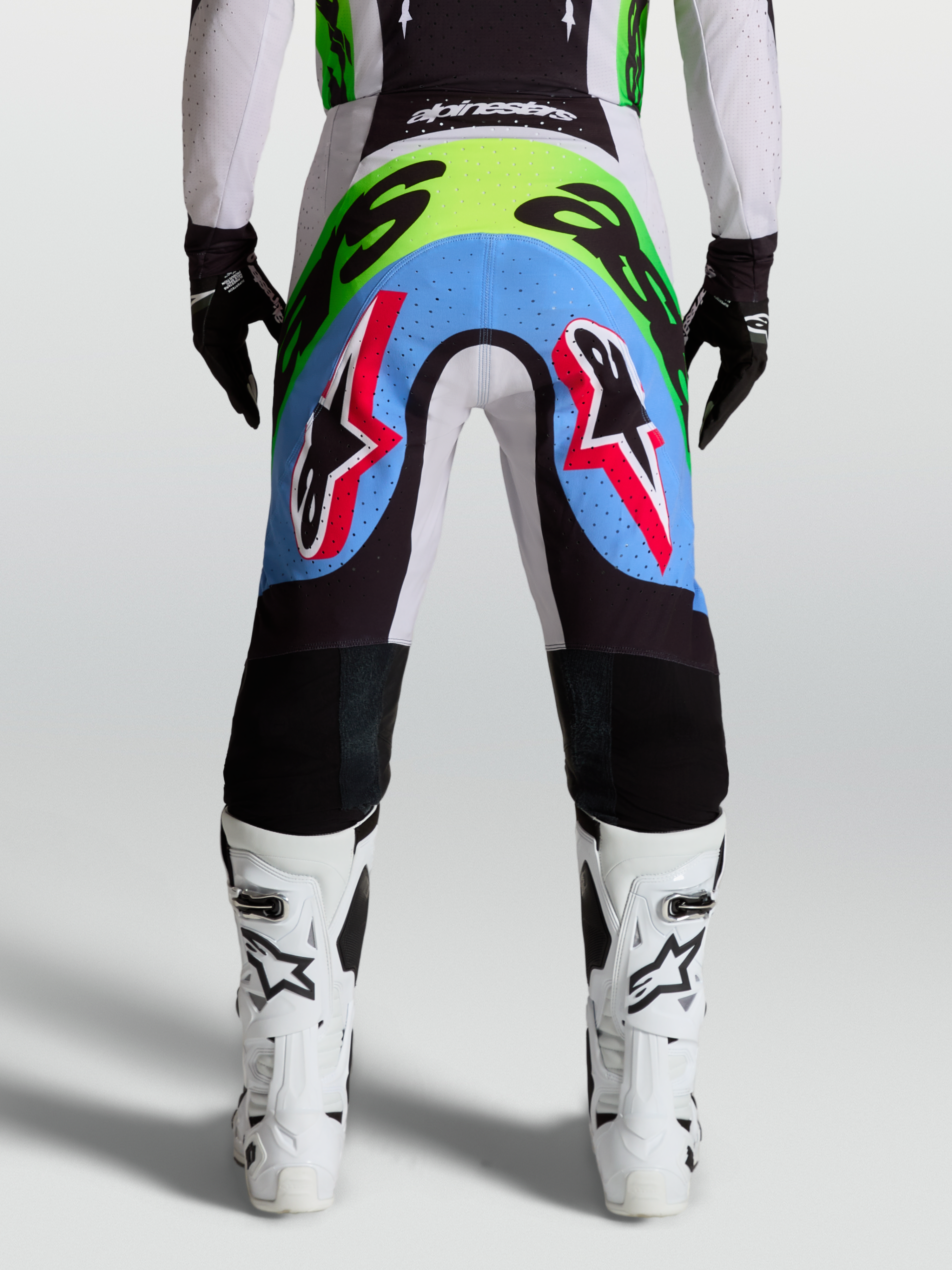 Alpinestars Supertech Dyna, męskie spodnie motocrossowe, jasny liliowy i neonowy zielony, widok z tyłu, perforowane panele.