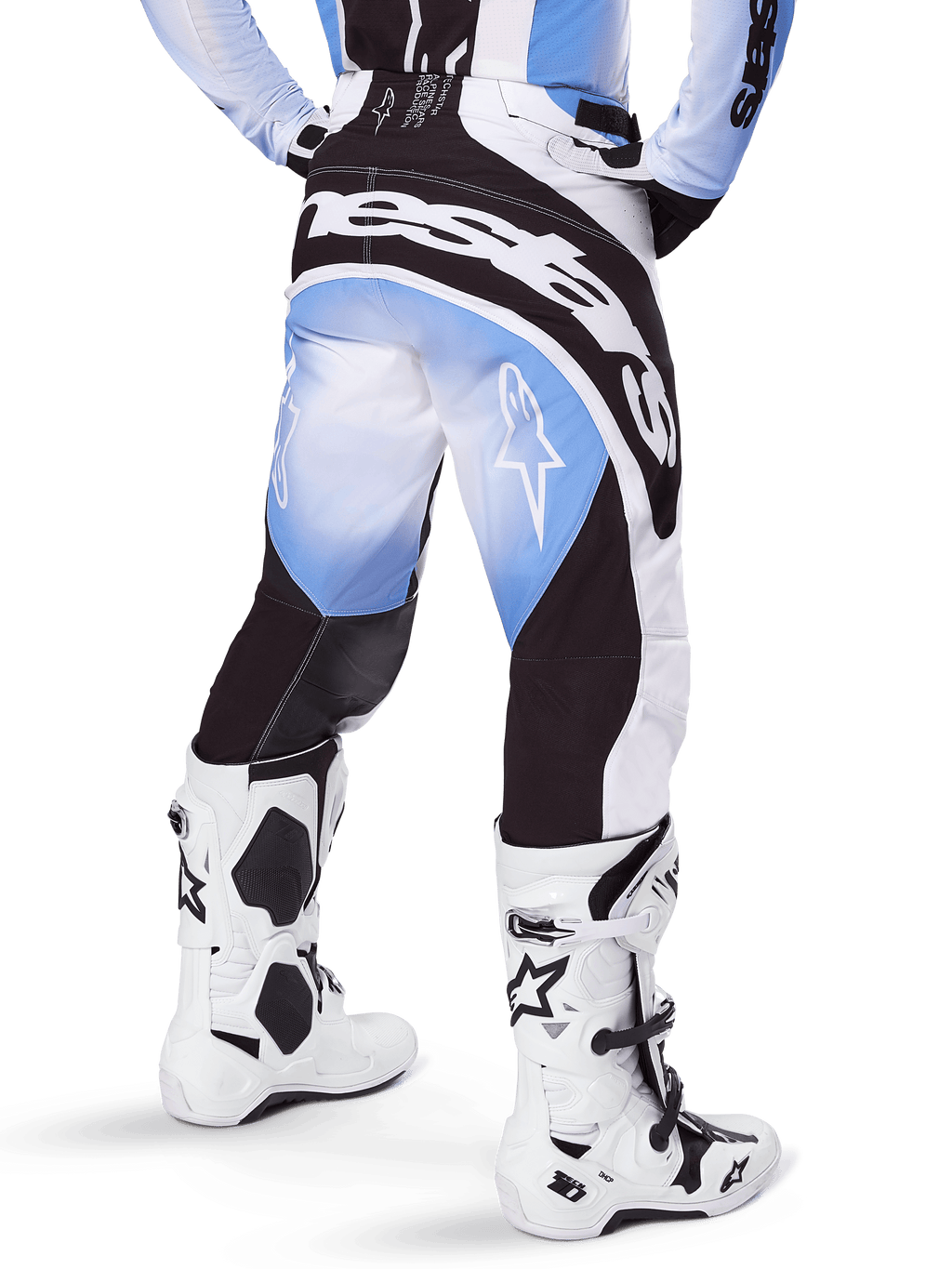 Alpinestars Techstar Melt Pants 2025, spodnie motocrossowe, czarno-niebiesko-białe, widok z tyłu z wyraźnym napisem Alpinestars na siedzeniu i logo gwiazdy na nogawkach, biało-czarne buty Tech 10, profesjonalna odzież off-road
