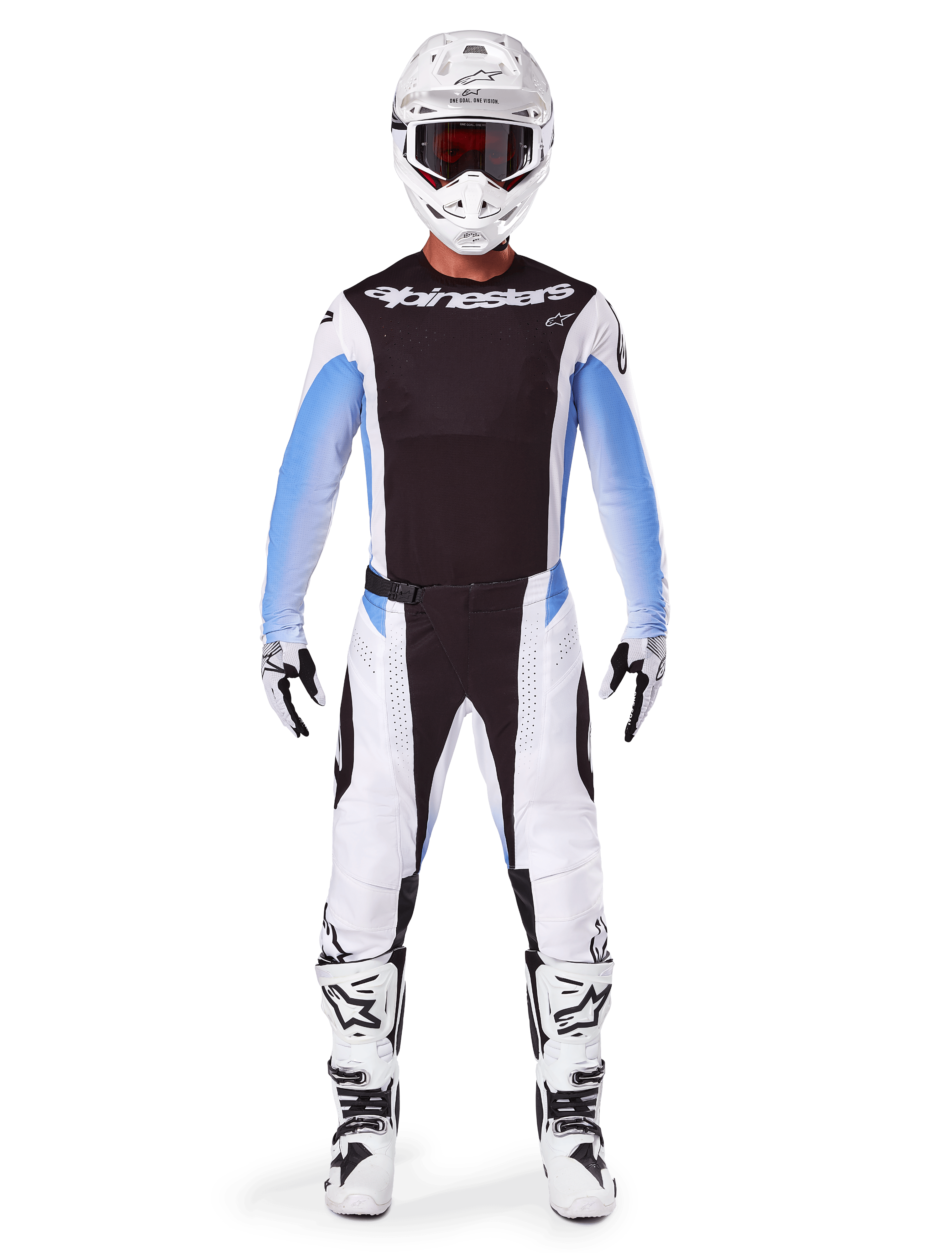 Motocrossowiec w spodniach Alpinestars 2025 Techstar Melt, spodnie motocrossowe, czarno-niebieskie, biało-czarna wielopanelowa konstrukcja z niebieskimi akcentami na biodrach, noszone z pasującą białą koszulką, białym kaskiem, białymi rękawicami i butami, kompletny zestaw do wyścigów terenowych