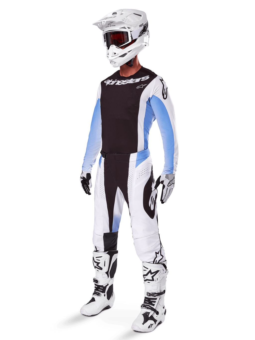 Motocyklista motocrossowy w spodniach Alpinestars 2025 Techstar Melt, biało-czarny strój motocrossowy z jasnoniebieskimi akcentami, dopasowana koszulka i rękawice, biały kask i gogle, biało-czarne buty wyścigowe, profesjonalny zestaw off-road