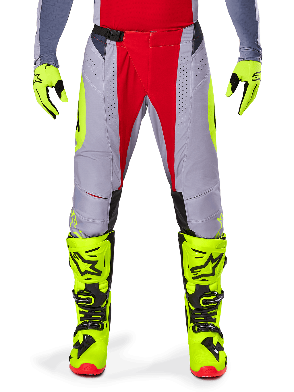 Spodnie Alpinestars Techstar Melt 2025, spodnie motocrossowe, jaskrawoczerwone i szare z fluorescencyjnymi żółtymi akcentami, noszone z dopasowanymi neonowożółtymi rękawicami i butami, z magnetyczną klamrą w pasie i laserowo wycinanymi perforacjami zapewniającymi wentylację.