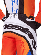 Alpinestars Techstar Melt Pants 2025, spodnie motocrossowe, pomarańczowo-niebieskie, zbliżenie na tylną część siedziska i pas, wyraźne czarne oznaczenia marki na białym tle, pomarańczowe panele z czerwonymi logo gwiazdy, wyczynowa odzież do wyścigów off-road