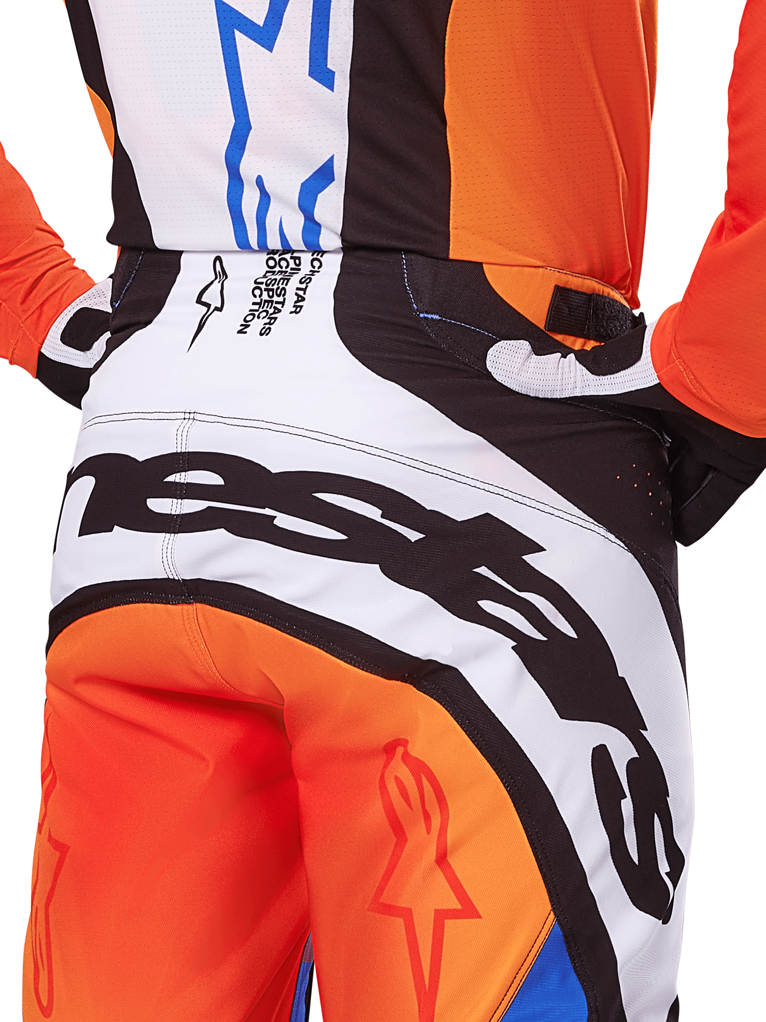 Alpinestars Techstar Melt Pants 2025, spodnie motocrossowe, pomarańczowo-niebieskie, zbliżenie na tylną część siedziska i pas, wyraźne czarne oznaczenia marki na białym tle, pomarańczowe panele z czerwonymi logo gwiazdy, wyczynowa odzież do wyścigów off-road
