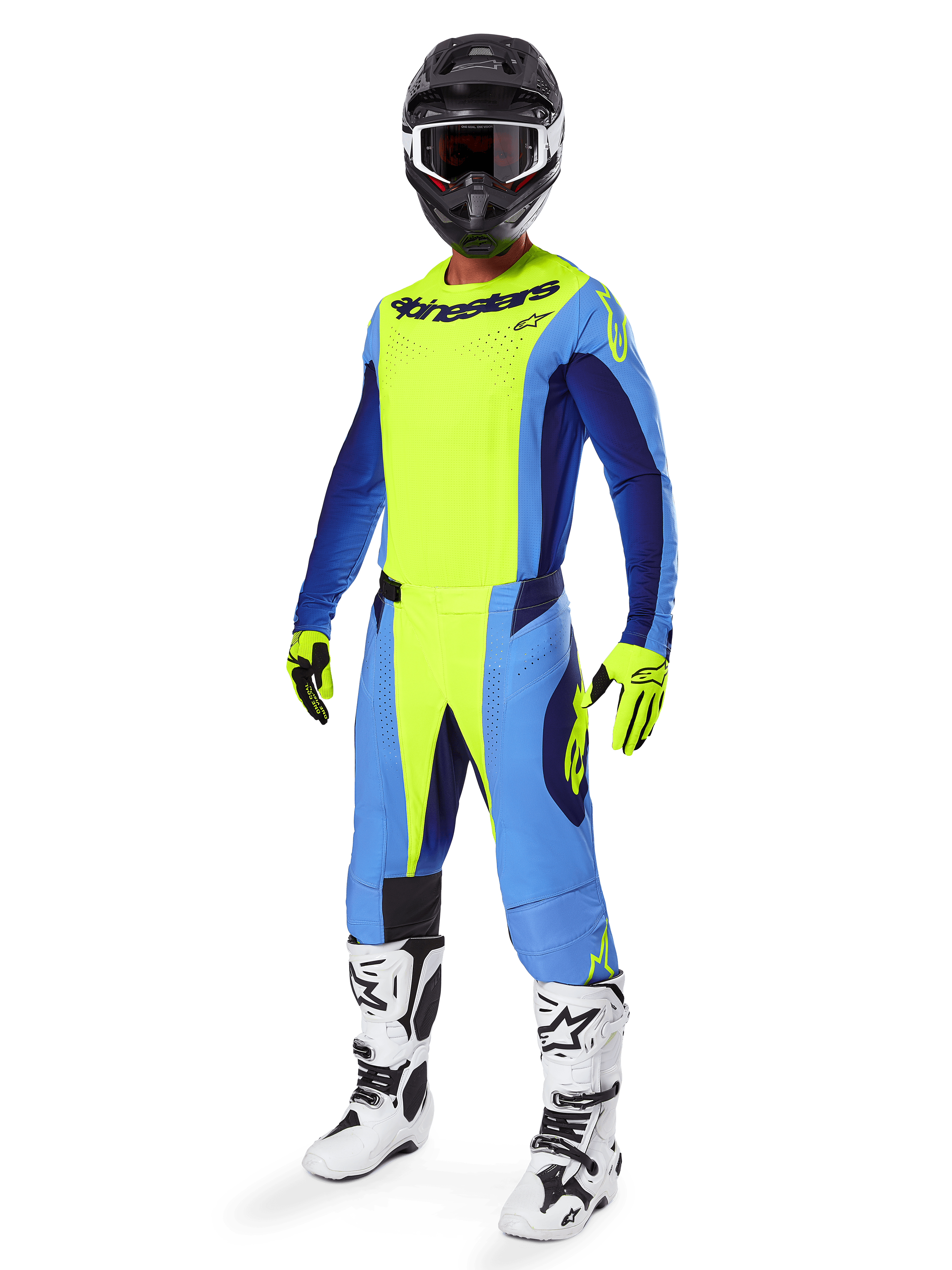 Alpinestars Techstar Melt Pants 2025, spodnie motocrossowe, żółty fluo i niebieski, noszone jako część kompletnego zestawu wyścigowego z dopasowaną koszulką, żółto-czarnymi rękawicami, biało-czarnymi butami oraz czarnym kaskiem z białymi goglami, skoordynowany wyczynowy strój off-road.