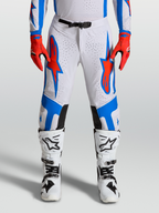 Alpinestars Spodnie Supertech Vesta, profesjonalne spodnie motocrossowe, białe z czerwono-niebieską grafiką, sportowy krój z perforacją i panelami Stretchnet.