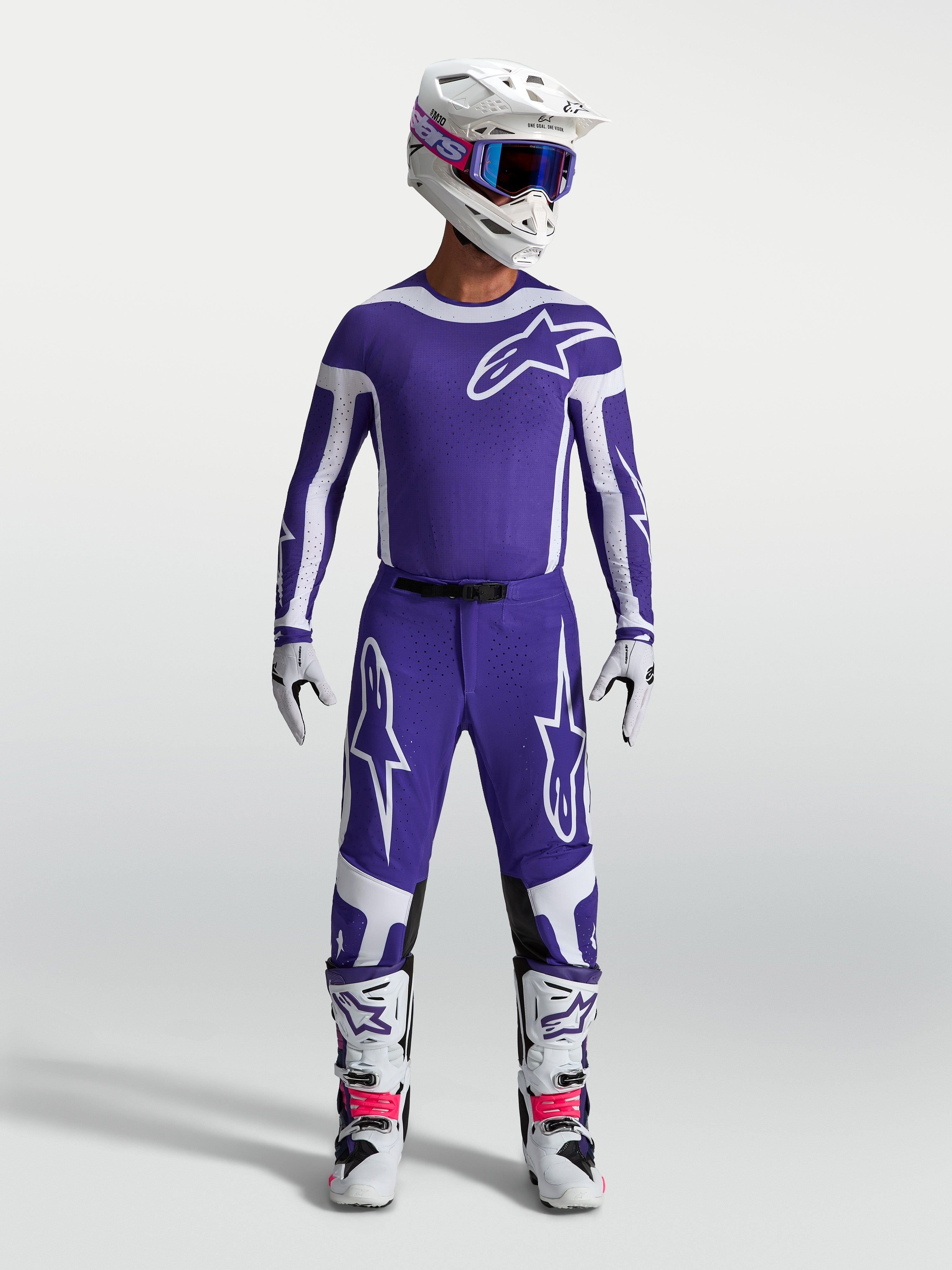 Spodnie Alpinestars Supertech Vesta, męskie spodnie motocrossowe, niebieskie i białe, sportowy krój z wytrzymałej tkaniny rip-stop, widok na modelu w pełnym stroju wyścigowym.