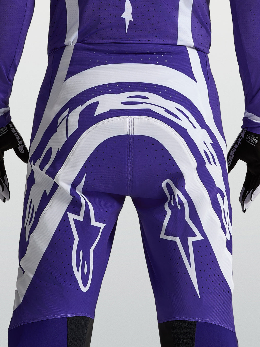 Alpinestars Spodnie Supertech Vesta, męskie spodnie motocrossowe, ciemnoniebieskie i białe, widok z tyłu prezentujący logo Astars oraz perforacje zapewniające wentylację podczas wyścigów.