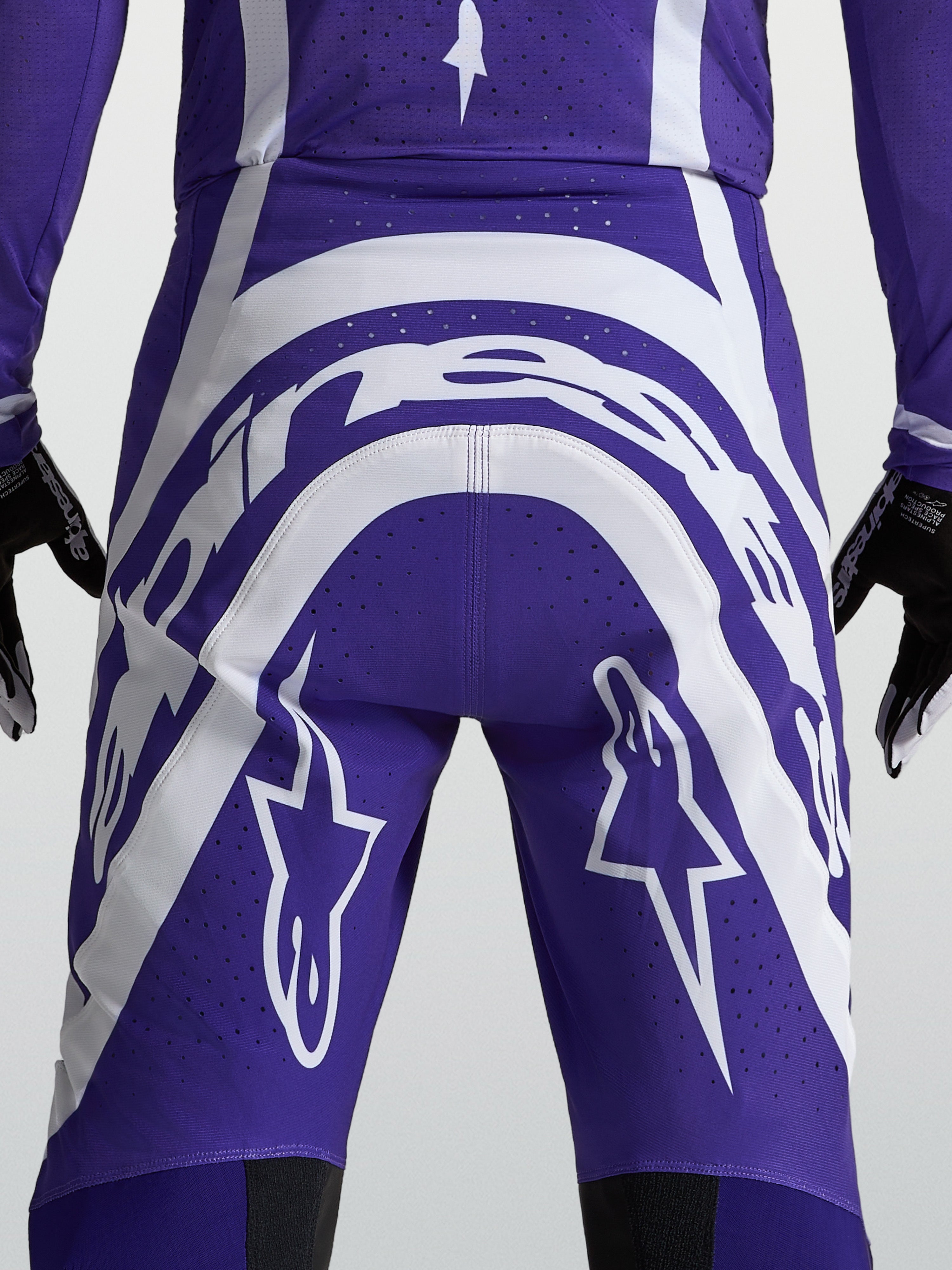 Alpinestars Spodnie Supertech Vesta, męskie spodnie motocrossowe, ciemnoniebieskie i białe, widok z tyłu prezentujący logo Astars oraz perforacje zapewniające wentylację podczas wyścigów.