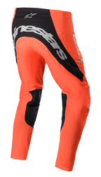 Alpinestars Supertech Risen Pants 2023, spodnie motocrossowe, jaskrawopomarańczowe i czarne, widok z tyłu z wyraźnym srebrnym logo na siedzeniu, czarnymi panelami po wewnętrznej stronie nogawek i perforowanymi strefami wentylacyjnymi do wyścigów terenowych