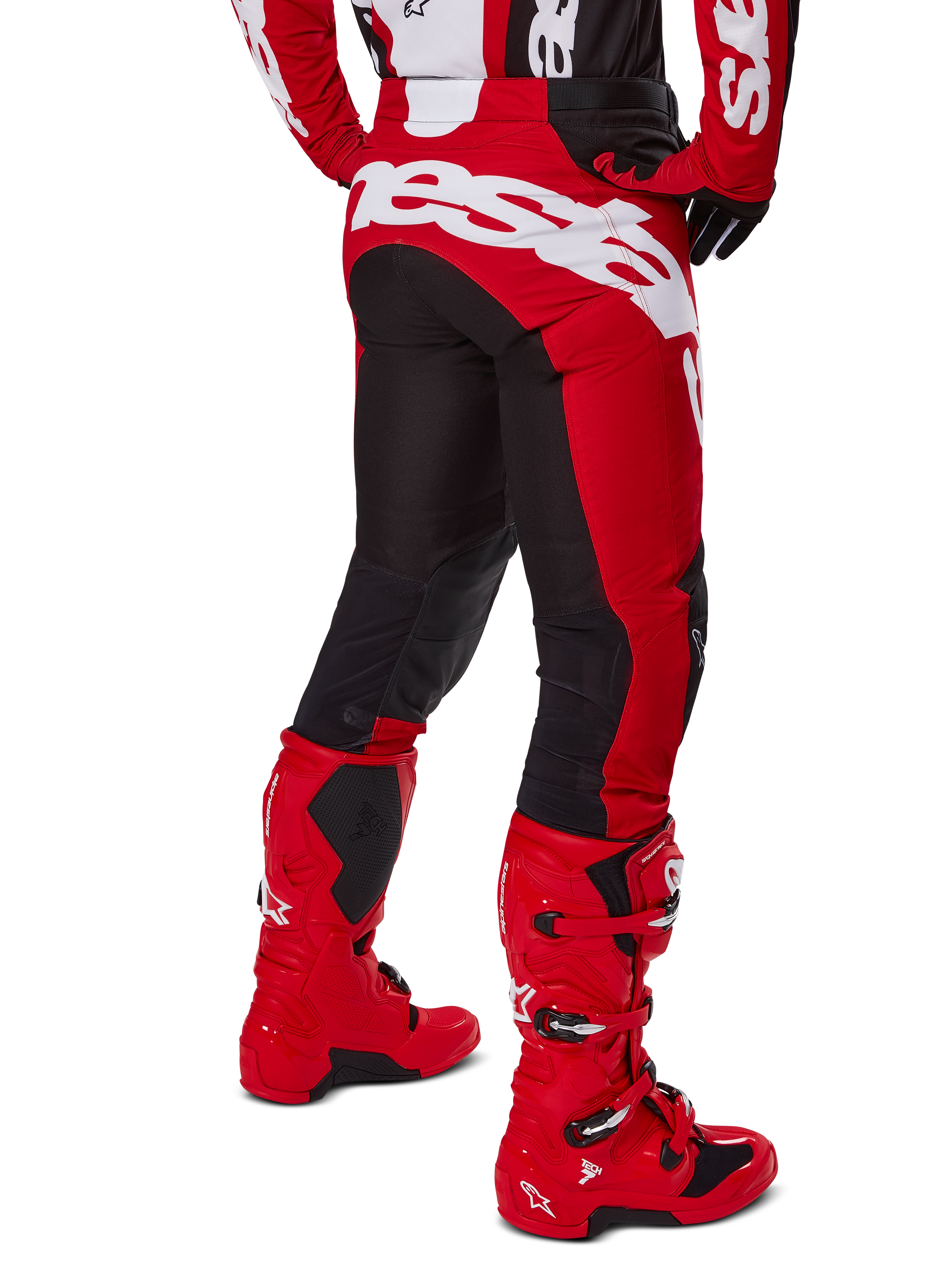 Alpinestars 2025 Racer Veil Gear Set, czerwono-czarny strój motocrossowy, widok z tyłu na czerwono-czarne spodnie z dużym białym logo, czerwone buty Tech 7 i dopasowana koszulka, wysokiej klasy sprzęt wyścigowy do jazdy off-road